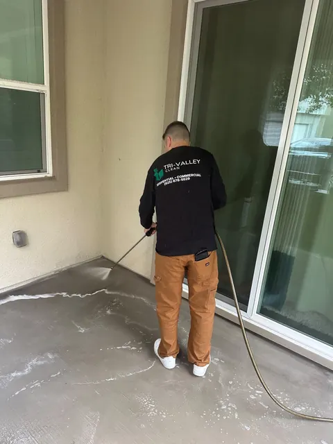 Pressure washing a patio by the sliding door