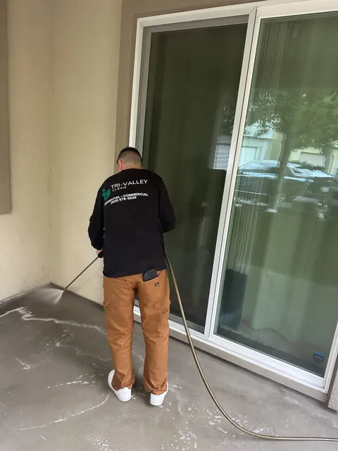 Pressure washing a patio by the sliding door