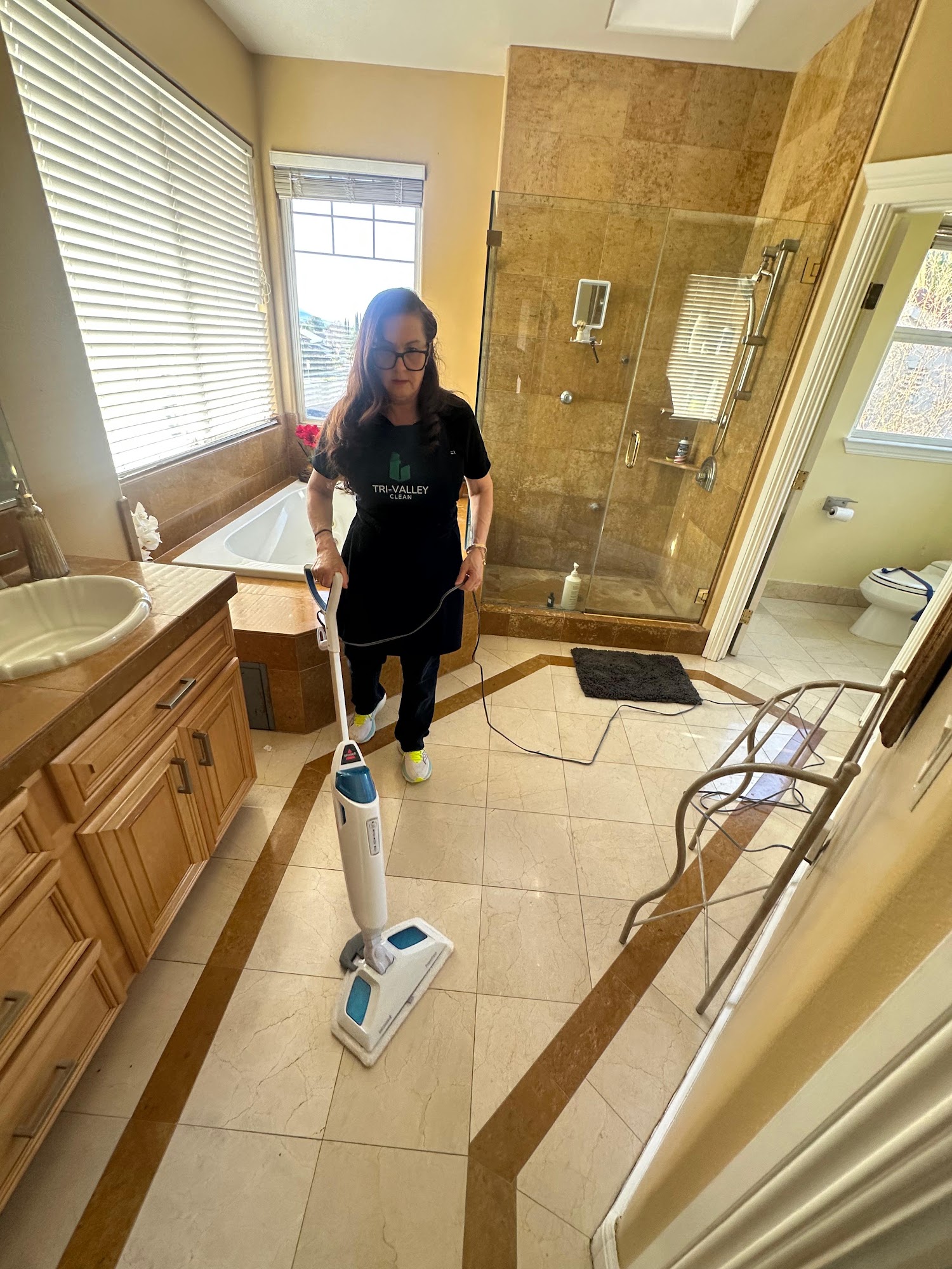 Tri-Valley Clean team member mopping a bathroom floor