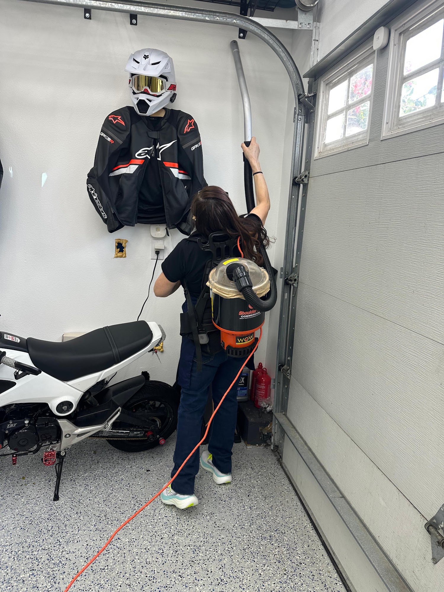 Tri-Valley Clean team member cleaning a garage with a backpack vacuum