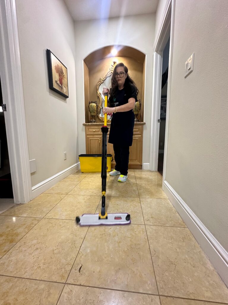Tri-Valley Clean team member mopping a tiled hallway