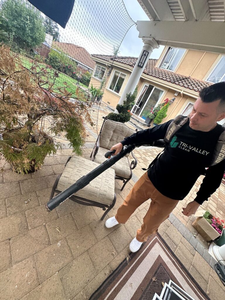 Tri-Valley Clean team member using a leaf blower on a patio