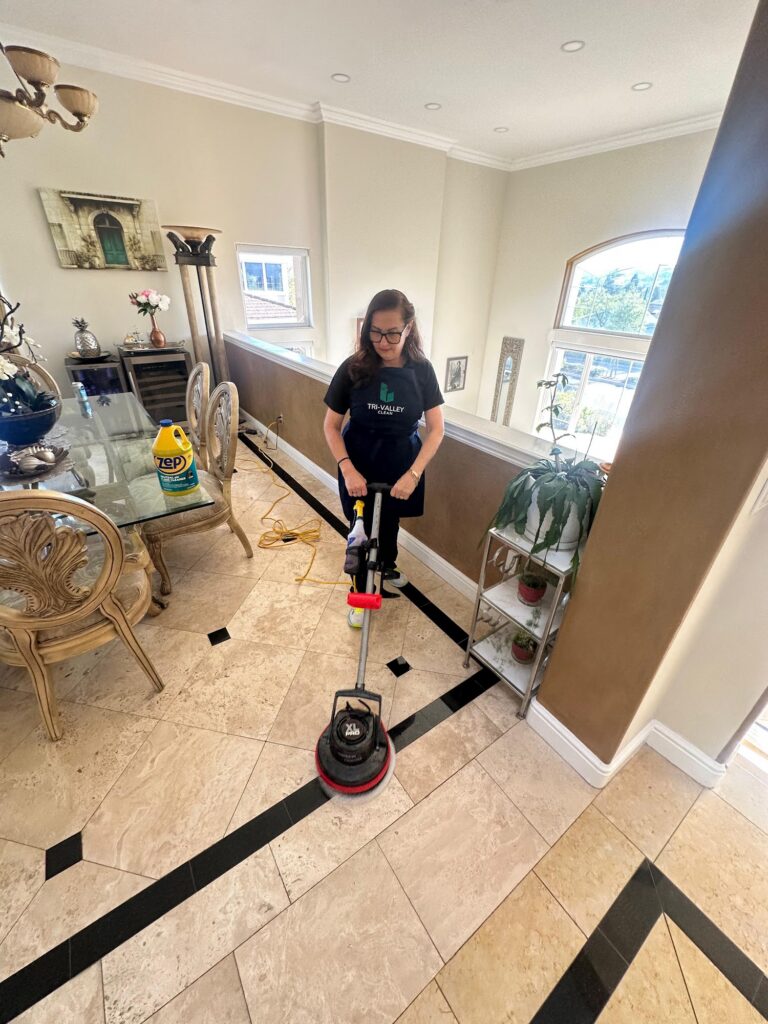Tri-Valley Clean team member scrubbing tile floors with a floor machine