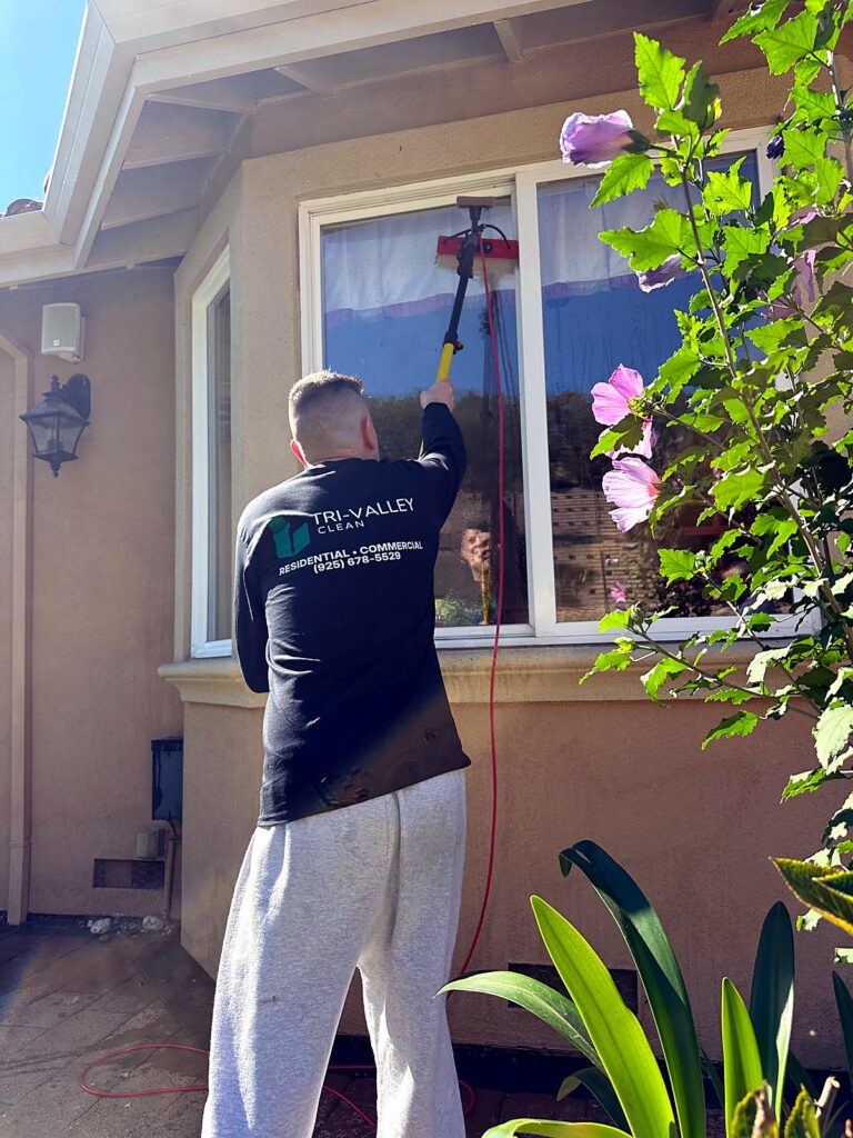 Tri-Valley Clean technician cleaning windows at a local home